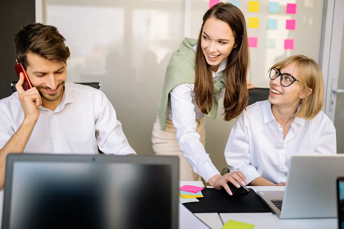 Office - people working on laptops, smiling.